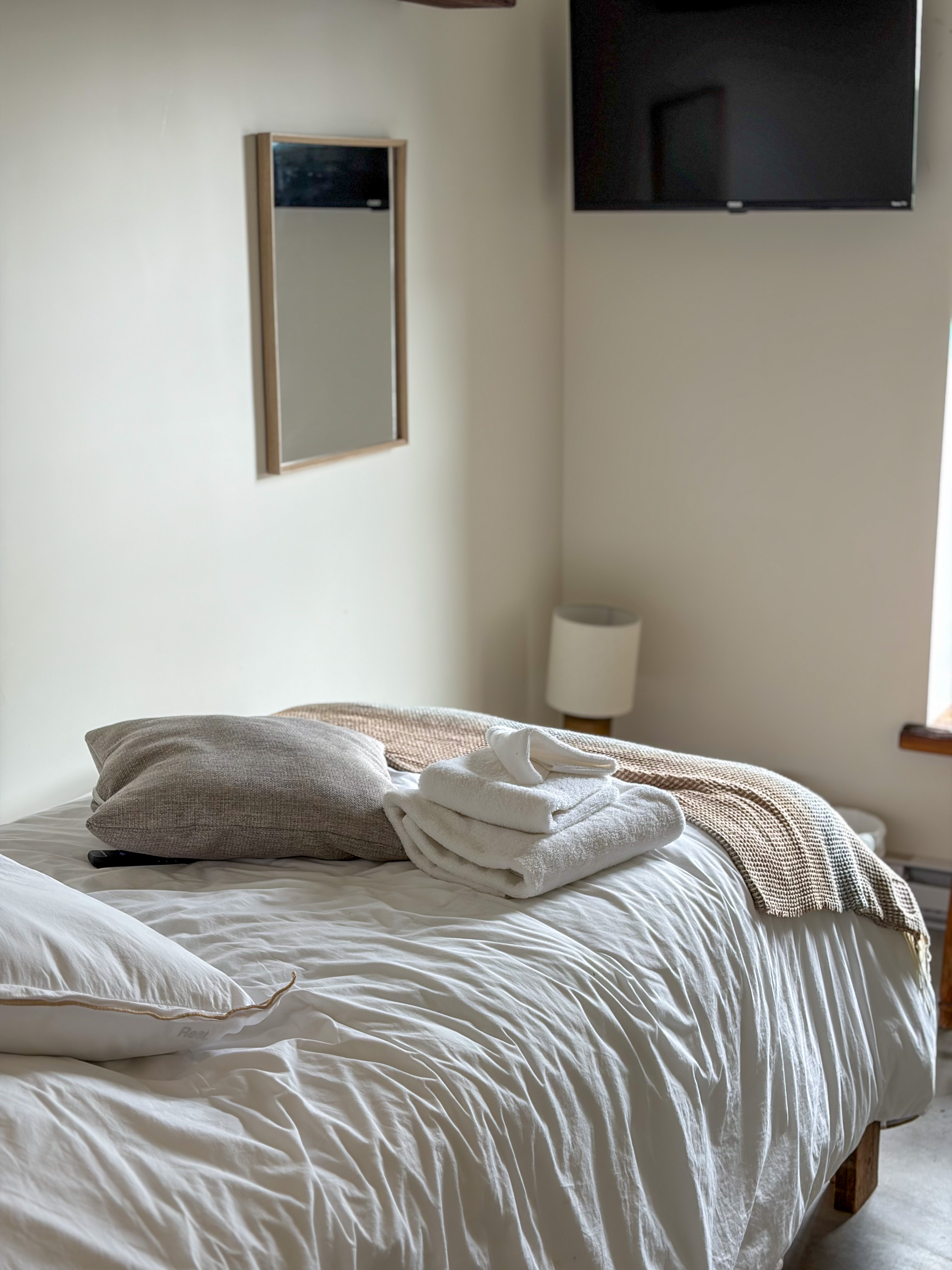 A bedroom with a double bed and a TV