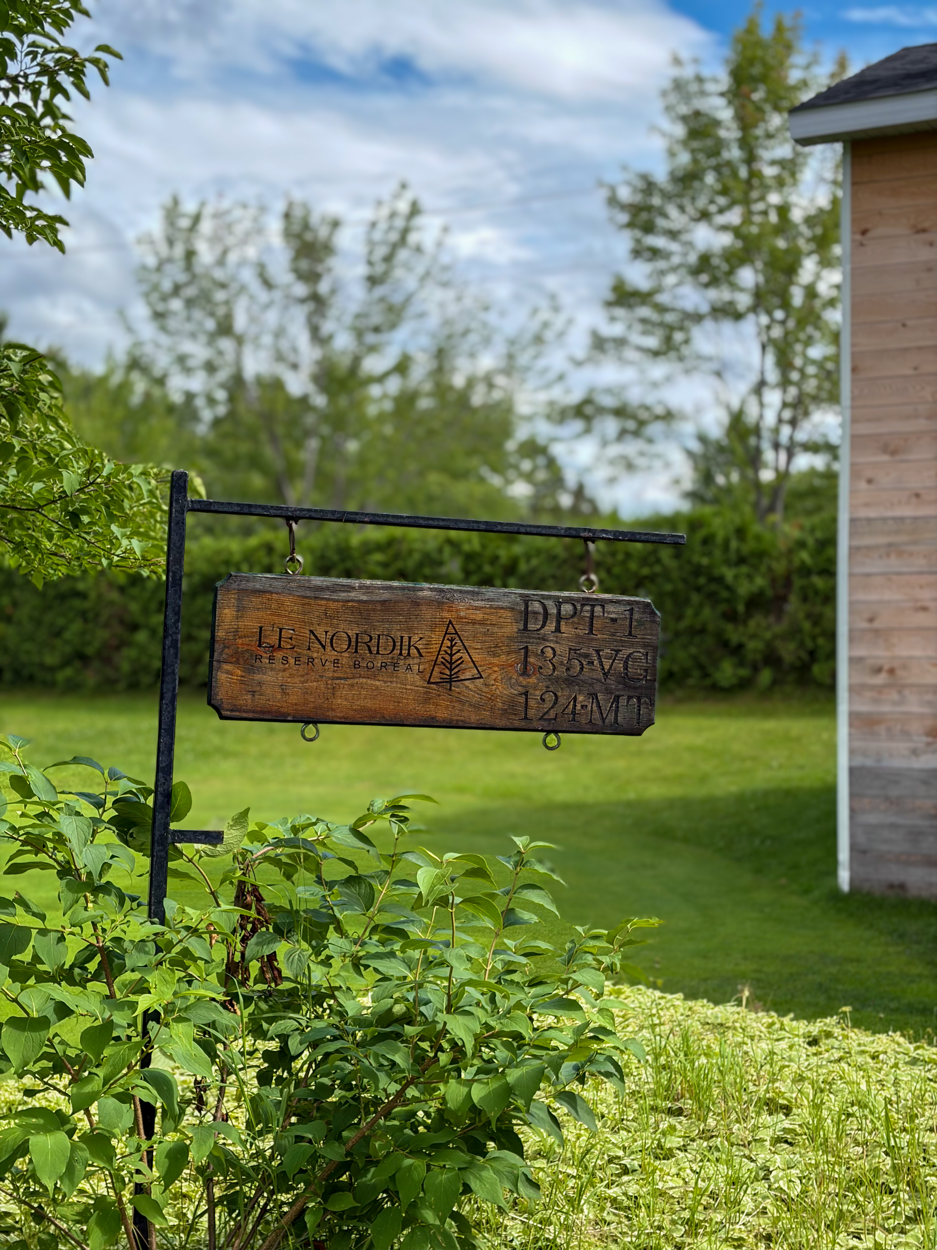 The estate's hanging sign surrounded by greenery