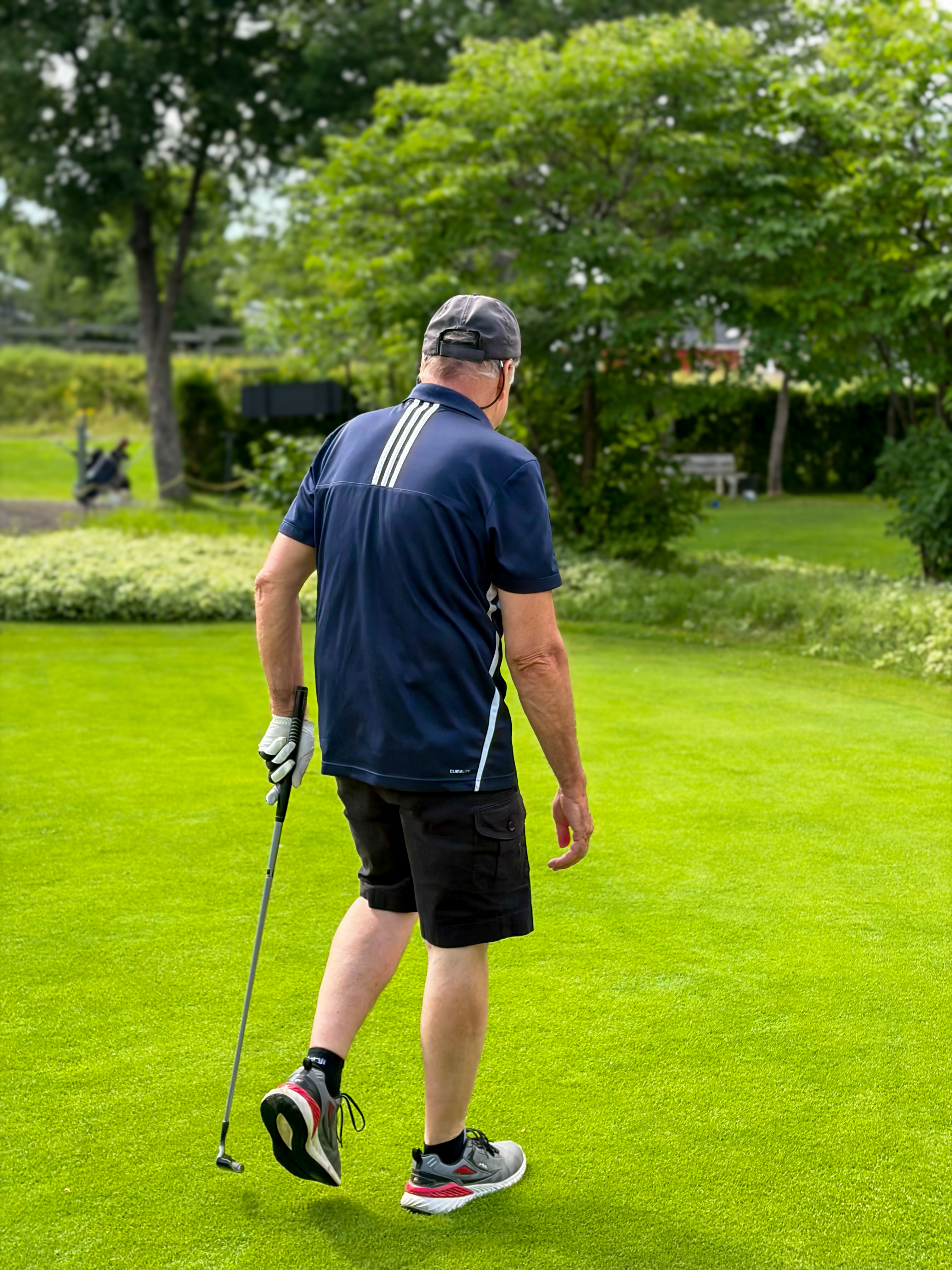 A golfer walking the green of the 9-hole course