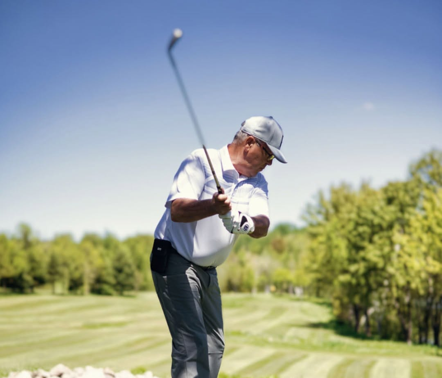 A golfer mid-swing on the estate's course