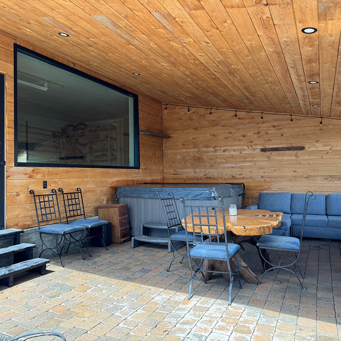 A covered patio with lounge furniture and a screen